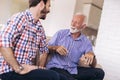 Senior Father With Adult Son Relaxing On Sofa Royalty Free Stock Photo