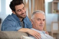 Senior father with adult son relaxing on sofa at home Royalty Free Stock Photo