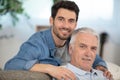 senior father with adult son relaxing on sofa at home Royalty Free Stock Photo