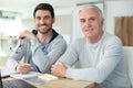 senior father with adult son relaxing on sofa at home Royalty Free Stock Photo