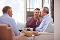 Senior Father With Adult Son Relaxing On Sofa At Home Royalty Free Stock Photo