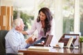 Senior Father Discussing Document With Adult Daughter