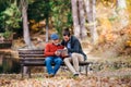 Senior father and his son sitting on bench in nature, using tablet. Royalty Free Stock Photo