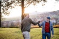 Senior father and his son on walk in nature, giving high five. Royalty Free Stock Photo