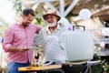 Senior father and mature son grilling together at garden bbq party. Man looking at full plate with grilled food. Royalty Free Stock Photo