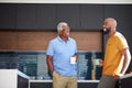 Senior Father Talking And Drinking Coffee With Adult Son In Kitchen At Home Royalty Free Stock Photo
