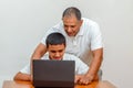 Happy family old grandfather and grandson on laptop.Elderly teacher trainer and teen pupil boy. Royalty Free Stock Photo