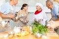 Senior female chef giving culinary classes to group of people Royalty Free Stock Photo