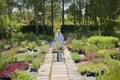 Senior Female Customer Pushing Trolley In Garden Centre Choosing Plants