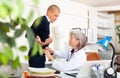 Senior female doctor palpating abdomen of male patient