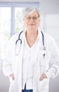 Senior female doctor smiling at hospital corridor Royalty Free Stock Photo