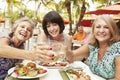 Senior Female Friends Eating Meal In Outdoor Restaurant