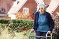 Senior Female In Garden Using Walking Frame Royalty Free Stock Photo