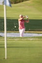 Senior Female Golfer Playing Bunker Shot