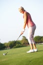 Senior Female Golfer Teeing Off Royalty Free Stock Photo