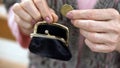 Senior female hand putting cent coin in wallet, budget and money saving, closeup Royalty Free Stock Photo