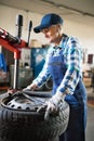 Senior female mechanic repairing a car in a garage. Royalty Free Stock Photo