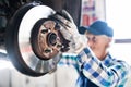 Senior female mechanic repairing a car in a garage. Royalty Free Stock Photo