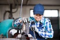 Senior female mechanic repairing a car in a garage. Royalty Free Stock Photo