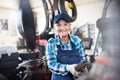 Senior female mechanic repairing a car in a garage. Royalty Free Stock Photo