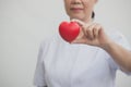Senior female nurse holding red heart symbol in her hand Royalty Free Stock Photo