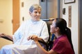 Senior Female Patient Being Pushed In Wheelchair By Nurse