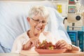 Senior Female Patient Eating Grapes In Hospital Bed Royalty Free Stock Photo