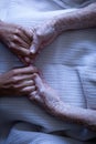 Senior female patient holding hands of surgeon in hospital corridor