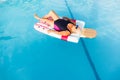 Senior female woman with bright sun glasses lies on a swimming pool inflatable icecream shaped float Royalty Free Stock Photo