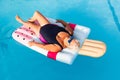 Senior female woman with bright sun glasses lies on a swimming pool inflatable icecream shaped float Royalty Free Stock Photo