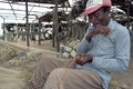 Senior fisherman sits to repair fishnet