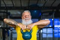 Senior fitness man doing kettle bell exercises inside gym - Fit mature male training in wellness club center Royalty Free Stock Photo