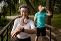 Senior fitness woman proud of overtaking her tired husband Royalty Free Stock Photo