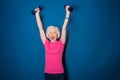 Senior fitness woman training with dumbbells isolated on blue Royalty Free Stock Photo