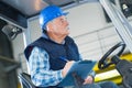 senior forklift driver making notes on clipboard Royalty Free Stock Photo