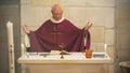 A Senior French Catholic priest is giving mass during a baptism in Aquitaine