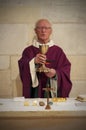 A Senior French Catholic priest is giving mass during a baptism in Aquitaine