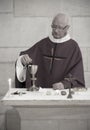 A Senior French Catholic priest is giving mass during a baptism in Aquitaine Royalty Free Stock Photo