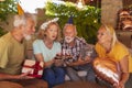 Senior friends blowing out candles on a birthday cake Royalty Free Stock Photo