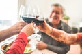 Senior friends cheering with red wine glasses at restaurant lunch - Happy mature people having fun drinking and eating together - Royalty Free Stock Photo