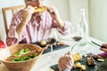 Senior friends having barbecue lunch at home - Old people having fun eating tasty meat and corn cob at bbq meal - Joyful elderly Royalty Free Stock Photo