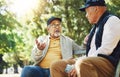 Senior friends, men and conversation on park bench, bonding and relax outdoor with phone. Elderly people sitting Royalty Free Stock Photo