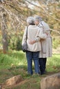 Senior friends, walk or hugging in nature by autumn leaves, together or care on retirement in park. Elderly women