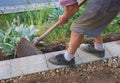 Senior gardener build a wall fundament