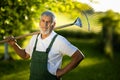 Senior gardener holding a grass rake, Royalty Free Stock Photo