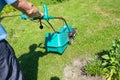 Senior gardener mowing his green lawn in garden. Man working on lawn cutting grass with lawn mower. man is mowing grass Royalty Free Stock Photo