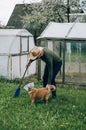 Senior gardener with a spade in the garden Young male gardener working in the greenhouse