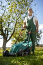 Senior gardenr gardening in his  garden - mowing the lawn Royalty Free Stock Photo