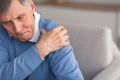 Senior Gentleman Having Shoulder Pain Sitting On Couch Royalty Free Stock Photo