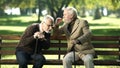 Senior gentlemen talking to his hearing impairment old friend, health problems Royalty Free Stock Photo